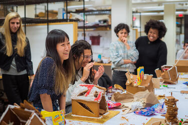 Group of students enjoys gingerbread house decorating activity