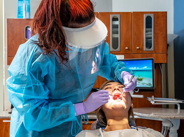 dental hygienist examining patient’s teeth