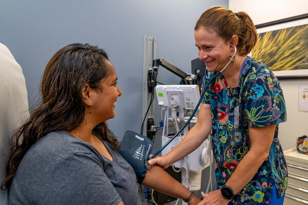 Nurse practicioner checks blood pressure for a patient