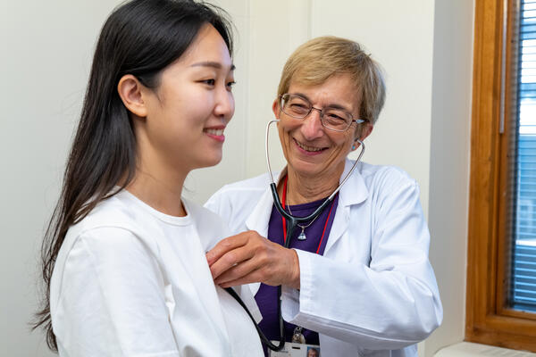 Smiling nurse practitioner examines patient